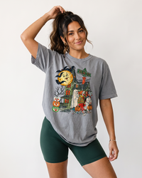 Woman wearing grey vintage trick or treat Halloween tee with Elm St haunted house graphic