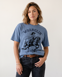 Woman wearing blue jean Wranglin My Feral Kids western mom heavyweight graphic tee